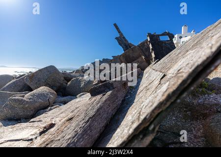 Zerfallenden hölzernen Rumpf von Schiffbruch Boot neben Felsen. Stockfoto