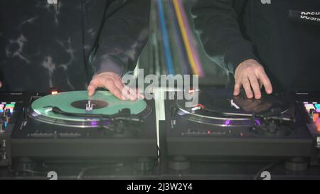 DJs spielen Platten in der Disco. Art. Nahaufnahme der Hand des DJs auf dem Mixer. Leuchtendes Musikpanel auf einer Party. Die Arbeit von Musikern in einem Nachtclub Stockfoto