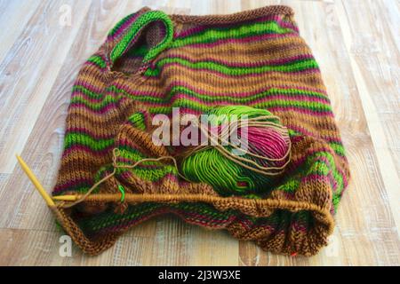 Gehäkelte gestrickte Quadrate, mehrfarbiger, warmer Strickpullover aus gestricktem Stoff, Strickstruktur, fuzziger Hintergrund Stockfoto