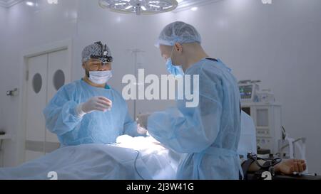 Ärzte . Aktion. Zwei Chirurgen, die die Operation im Krankenhaus mit allen Geräten durchführen. Stockfoto