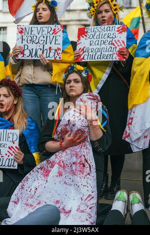 Ukrainische Frau protestiert gegen den ukrainisch-russischen Krieg mit einem blutbedeckten Baby. Pro-ukrainische Demonstration, steht mit der Ukraine Stockfoto