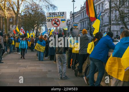 Demonstranten, die ukrainische Flaggen tragen, in Whitehall, London. Tausende von Menschen marschierten in Solidarität mit der Ukraine, während Russland seinen Angriff fortsetzt. Stockfoto