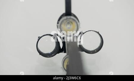 Nahaufnahme von zahnmedizinischen Instrumenten. Konzept der Medizin und Zahnmedizin. Aktion. Binokulare Ausrüstung isoliert auf weißem Wandhintergrund. Stockfoto