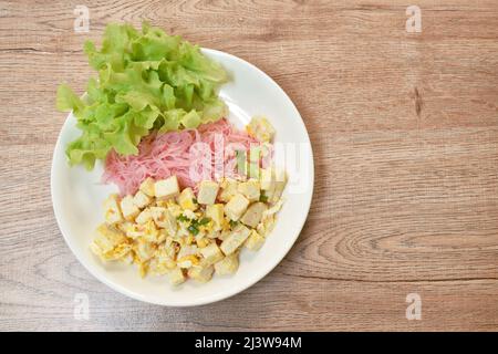 Gebratene Vermicelli mit Kokosmilch umrühren und in Scheiben schneiden und Tofu auf den Teller geben Stockfoto