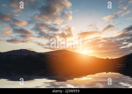 Sonnenuntergang mit intensiven Farben und schönen Wolken über einem See Stockfoto
