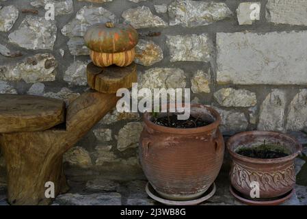 Alte traditionelle ländliche Haus Terrasse mit einer handgefertigten Steinwand ein Holzstuhl und handgefertigten Lehm Urnen in Karytaine, Arcadia Peloponnes Griechenland. Stockfoto