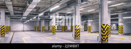 Leeres Einkaufszentrum in der Tiefgarage oder Garage mit betongestrichenen Säulen Stockfoto