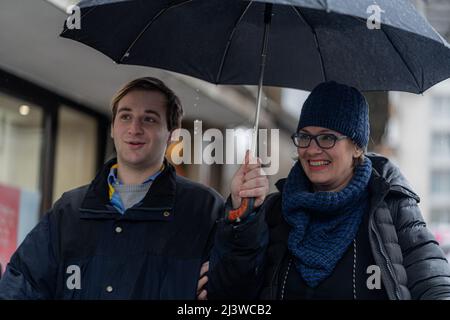 Zwei erstaunliche Geschäftsleute gehen schnell und lächeln, während sie aus nächster Nähe über die Unternehmenspläne sprechen Stockfoto