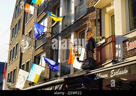 Verschiedene lokale und internationale Flaggen (EU-Flagge, Düsseldorf-Flagge, Ukraine-Flagge) vor einem Restaurant in der Düsseldorfer Altstadt. Stockfoto