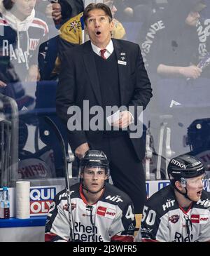 Berlin, Deutschland. 10. April 2022. Eishockey: DEL, Eisbären Berlin - Kölner Haie, Meisterschaftsrunde, Viertelfinale, Spieltag 1, Mercedes-Benz Arena. Trainer Uwe Krupp (hinten) von den Kölner Haien schaut sich die Anzeigetafel an. Quelle: Andreas Gora/dpa/Alamy Live News Stockfoto