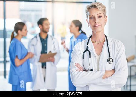 Beginnen Sie damit, das Notwendige zu tun. Aufnahme einer reifen Ärztin, die in einem Krankenhaus steht. Stockfoto