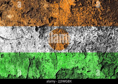 Verzweifelte niger-Flagge auf einer alten beschädigten Betonmauer Stockfoto