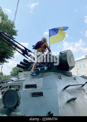 Kind spielt auf einer militärischen Anlage im Park Stockfoto