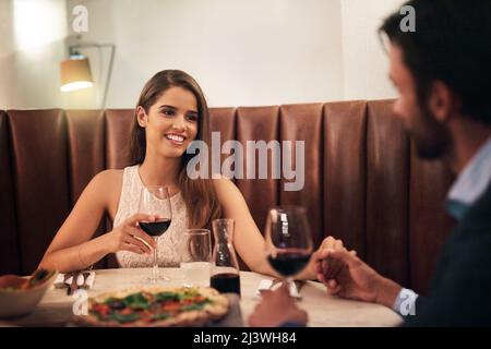 Hes alles, was ich will. Aufnahme eines glücklichen jungen Paares, das ein romantisches Dinner in einem Restaurant genießt. Stockfoto