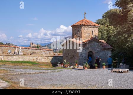 Mzcheta, Georgien - 23. September 2018: Die alte Kirche des heiligen Nino im Kloster Samtavro. Die Festung Bebris tsikhe im Hintergrund Stockfoto