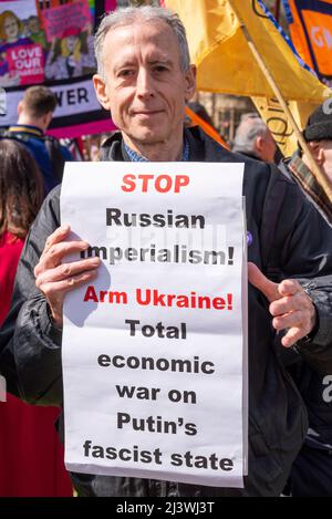 Peter Tatchell auf einem Stand mit Protest der Ukraine auf dem Parliament Square, Westminster, London, Großbritannien. Plakat, russischer Imperialismus, bewaffnet die Ukraine, Krieg gegen Putin Stockfoto