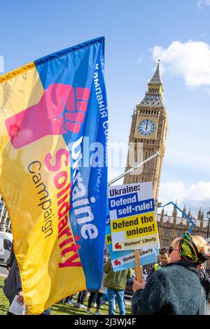 Stellen Sie sich mit dem Protest der Ukraine auf dem Parliament Square, Westminster, London, Großbritannien, auf. Solidarität mit der ukrainischen Flagge, von Big Ben, Elizabeth Tower of Parliament Stockfoto