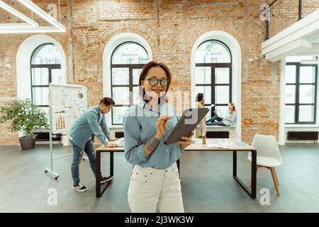 Porträt einer glücklichen Frau mit Tablet im Büro. Stockfoto