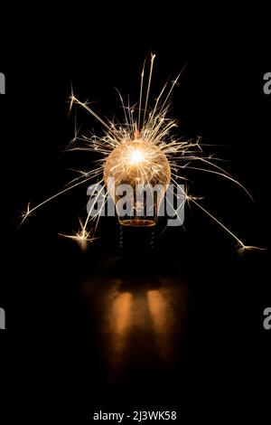 Glühlampe mit Funken auf schwarzem Hintergrund. Stockfoto