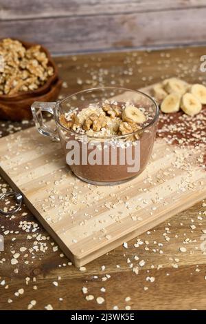 Gesunder Smoothie mit Banane und Kakao auf braunem Hintergrund Stockfoto