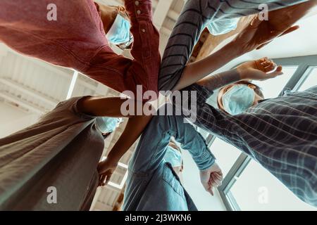 Die Schüler stoßen ihre Ellbogen an, anstatt sie mit einer Umarmung zu begrüßen Stockfoto