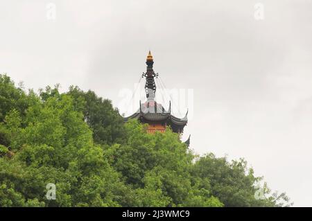 Die Cishou-Pagode erhebt sich an einem bewölkten Tag in der Provinz Jiangsu über den Bäumen im malerischen Gebiet des Jinshan-buddhistischen Tempels in Zhenjiang China. Stockfoto