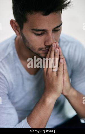 Gib uns heute unser tägliches Brot. Aufnahme eines jungen Mannes, der betet. Stockfoto