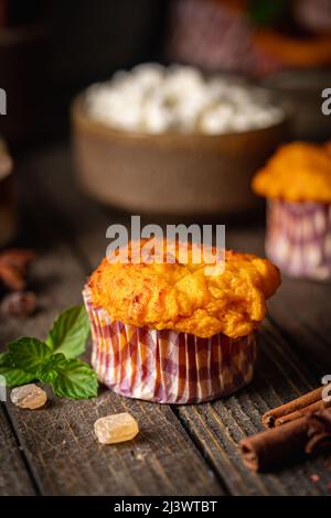 Süße hausgemachte Hüttenkäse-Muffins mit Kürbis auf dunklem Holzhintergrund Stockfoto