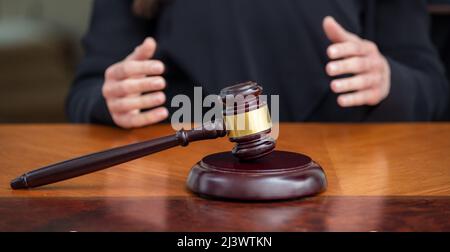 Richter gavel auf hölzernen Gericht Bank, verwischen weibliche Hände, Nahaufnahme. Gerechtigkeit und Strafe Konzept Stockfoto