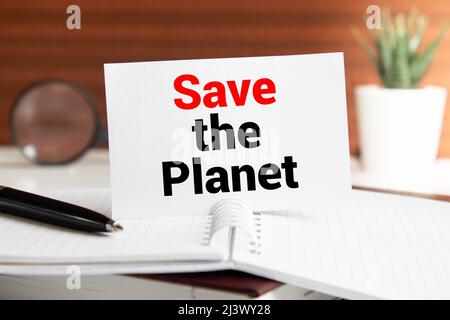 Nahaufnahme einer beschrifteten Tafel mit dem Text rette den Planeten im Stamm eines Baumes. Stockfoto