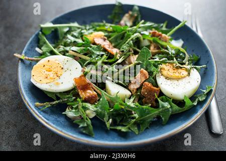 Dandelionensalat mit Eiern und gebratenem Speck aus nächster Nähe Stockfoto