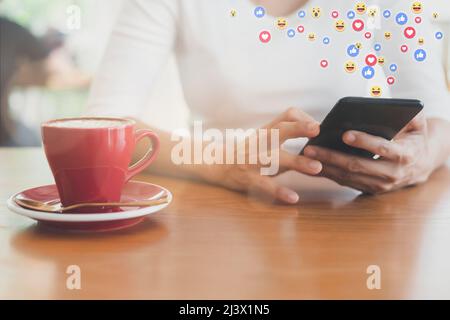 Asiatische Frau sitzt im Coffeeshop entspannen mit Handy. Junge Frau entspannen sich nur mit Social Media. Frauen mit dem Smartphone halten und tippen w Stockfoto