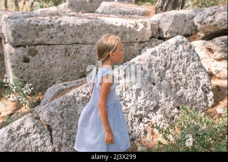 Junge Mädchen Reisenden von acht Jahren reisen und erkunden Sie die alten Ausgrabungen der Ruinen der alten lykischen Stadt Phaselis in der Türkei während s Stockfoto