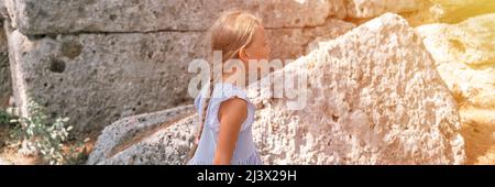 Junge Mädchen Reisende von acht Jahren reisen und erkunden die alten Ausgrabungen der Ruinen der alten lykischen Stadt Phaselis in der Türkei in Summe Stockfoto