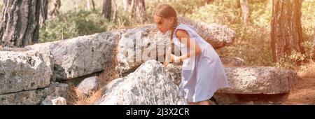 Junge Mädchen Reisende von acht Jahren reisen und erkunden die alten Ausgrabungen der Ruinen der alten lykischen Stadt Phaselis in der Türkei in Summe Stockfoto