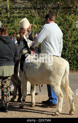 Erzbischof von Canterbury, Justin Welby, am Palmsonntag mit einem Esel vor der St. Mary's Kirche, Brabourne, Ashford, Kent, England, Vereinigtes Königreich Stockfoto