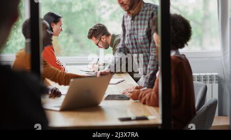 Das multinationale Business-Team arbeitet in einer modernen Halle der Kuhhirten Stockfoto
