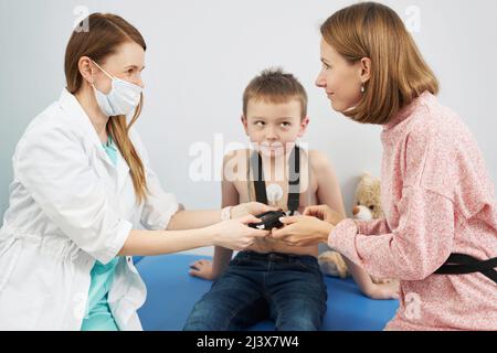 Kinderarzt überprüft den Herzrhythmus des Kindes mit dem EKG-holter-Monitor Stockfoto