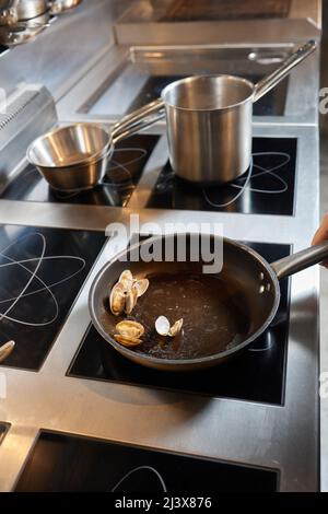 Frittieren Küchenchef Muscheln auf kommerzielle Küche im Restaurant, in der Nähe der Hände Stockfoto