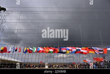 Weimar, Deutschland. 10. April 2022. Auf dem Rollladenplatz der Gedenkstätte Buchenwald bei Weimar fliegen Flaggen während einer Gedenkfeier zur Befreiung des ehemaligen Nazi-Konzentrationslagers vor 77 Jahren. In Buchenwald gedachten rund 500 Menschen der Befreiung des Lagers am 11. April 1945. Vertreter der Regierungen Russlands und Weißrusslands waren von der Gedenkstätte abberufen worden. Quelle: Martin Schutt/dpa/Alamy Live News Stockfoto