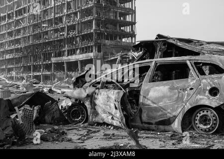 Nach der Shell von Zivilisten bombardiert Stadt Schaden Auto. 2022 Russische Invasion der Ukraine Krieg zerrissene Stadt zerstört Auto brennen aus. Bombe Angriff Russland Krieg Stockfoto