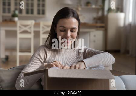 Glückliche junge Kundin, die im Internet-Shop gekauft wurde Stockfoto