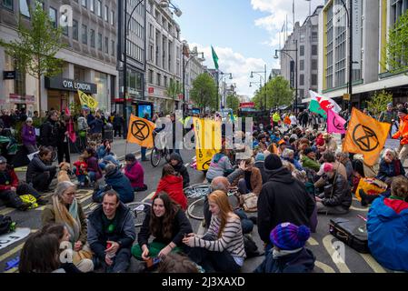 Extinction Rebellion Protestierende startenden in London ab dem 9. April 2022 eine Phase ziviler Störungen. Sich hinsetzen, um die Oxford Street zu besetzen Stockfoto