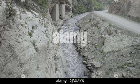 Zwischen die Seiten der Felsen wird ein mächtiger Wasserstrom gequetscht. Aktion. Luftaufnahme des Flusses, der in einer Schlucht zwischen Bergen fließt. Stockfoto