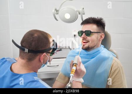 Lächelnder Mann, der im HNO-Büro behandelt wird Stockfoto