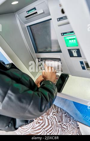 Lady benutzt Geldautomaten, um ihr Geld abzuheben. Nahaufnahme der Eingabe von PIN oder Passcode über die Tastatur des Geldautomaten. Sicherheitscode auf Automated Teller Stockfoto