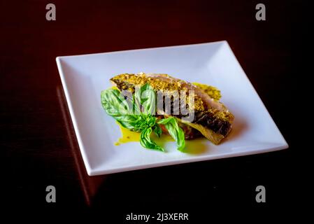 Gegrillter Fisch mit Gemüse auf schwarzem Hintergrund Stockfoto