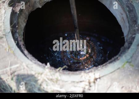 Rohrbruch im Kanal. Reparatur von Leitungen im Untergrund. Öffnen Sie die Klappe. Unfall in der Kommunikation. Flüssigkeitsfluss. Stockfoto