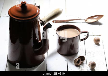 Heißer Schokoladendrink in einem emaillierten Becher aus Vintage-Emaille auf Holzhintergrund Stockfoto