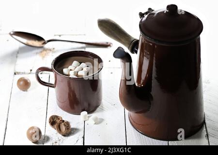 Heißer Schokoladendrink in einem emaillierten Becher aus Vintage-Emaille auf Holzhintergrund Stockfoto